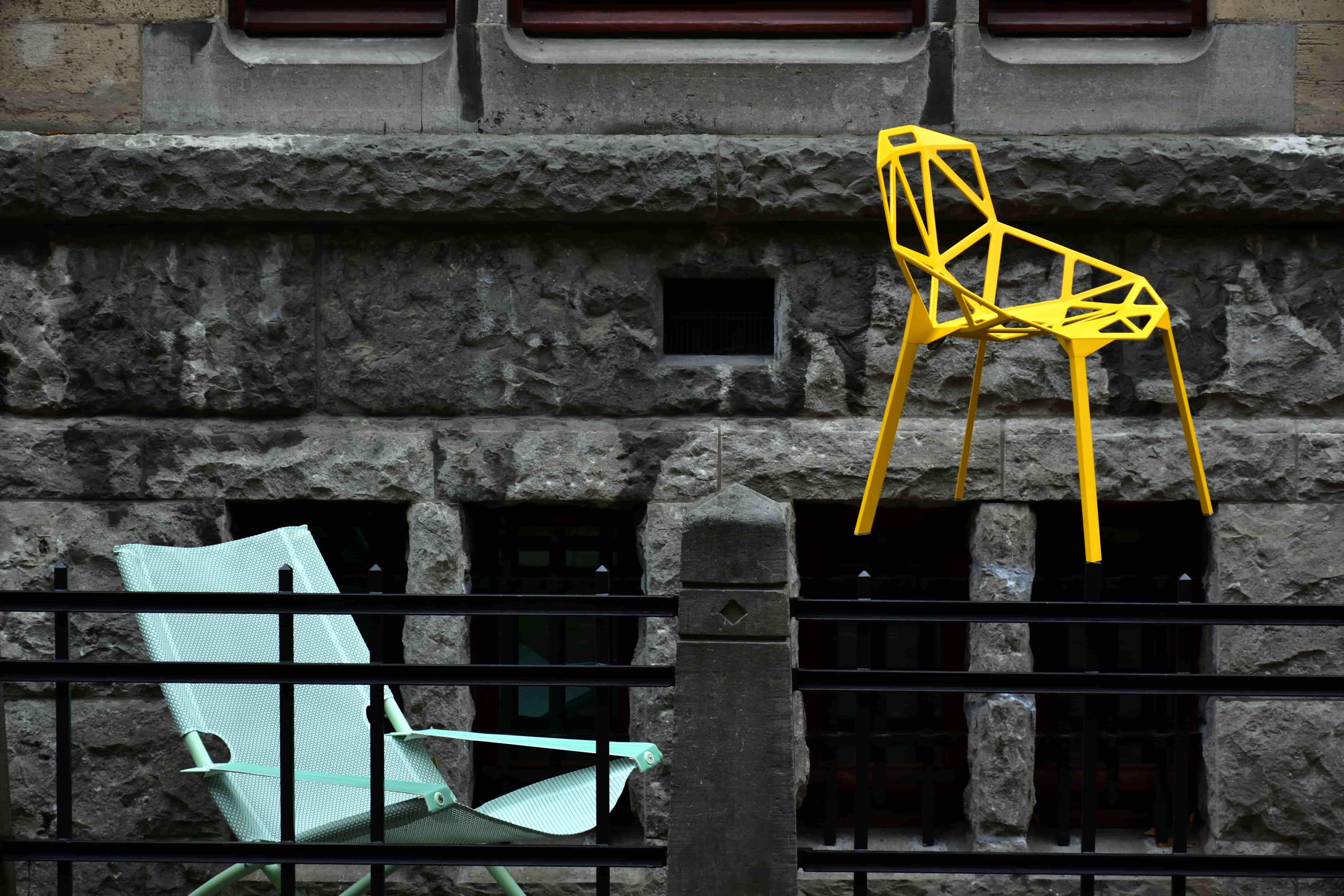 A yellow chair sitting on top of a cement wall